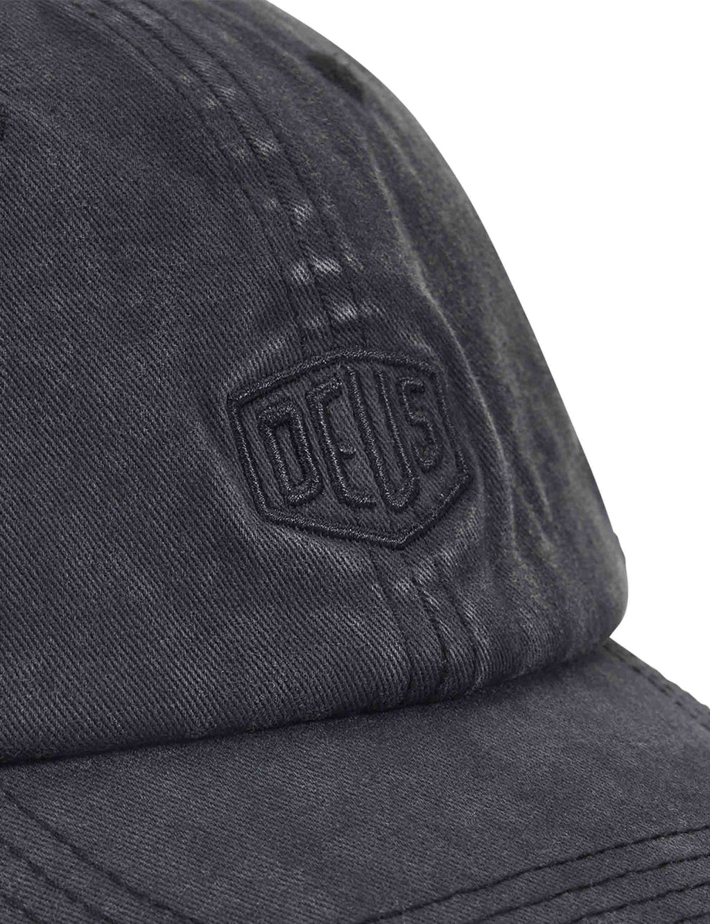 Black dad cap close-up of embroidered shield logo on fabric