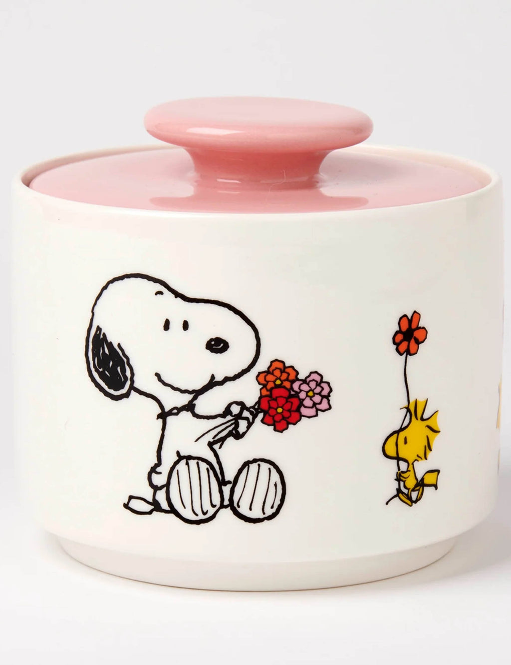 White ceramic candy jar with pink lid, Snoopy holding flowers and small yellow figure