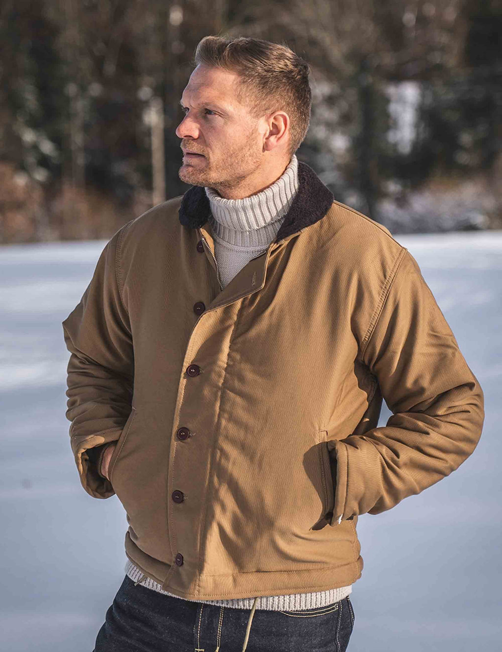 Men’s tan deck jacket with ribbed knit collar, button front, and black lining trim