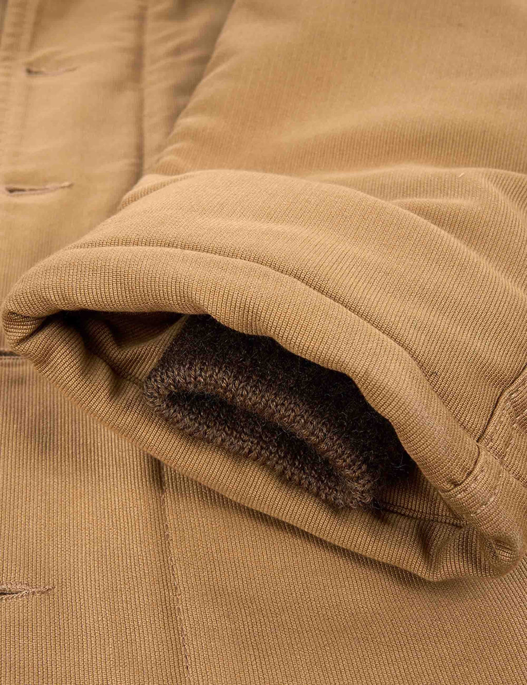 Tan sleeve cuff with ribbed knit edge and dark knit inner cuff
