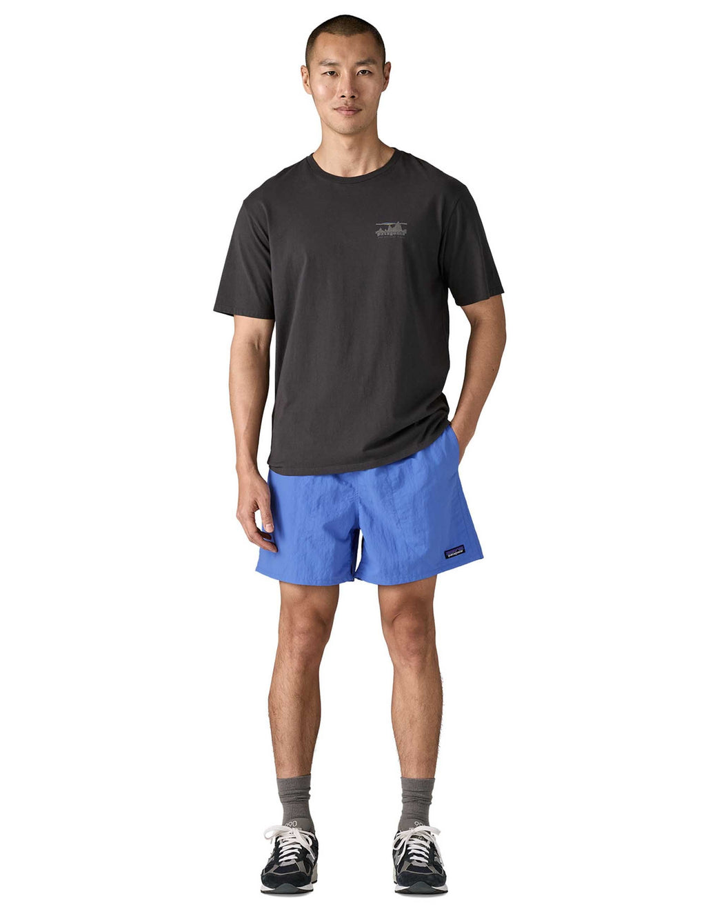 Blue pull-on shorts on model, with elastic waistband and small logo patch at hem.