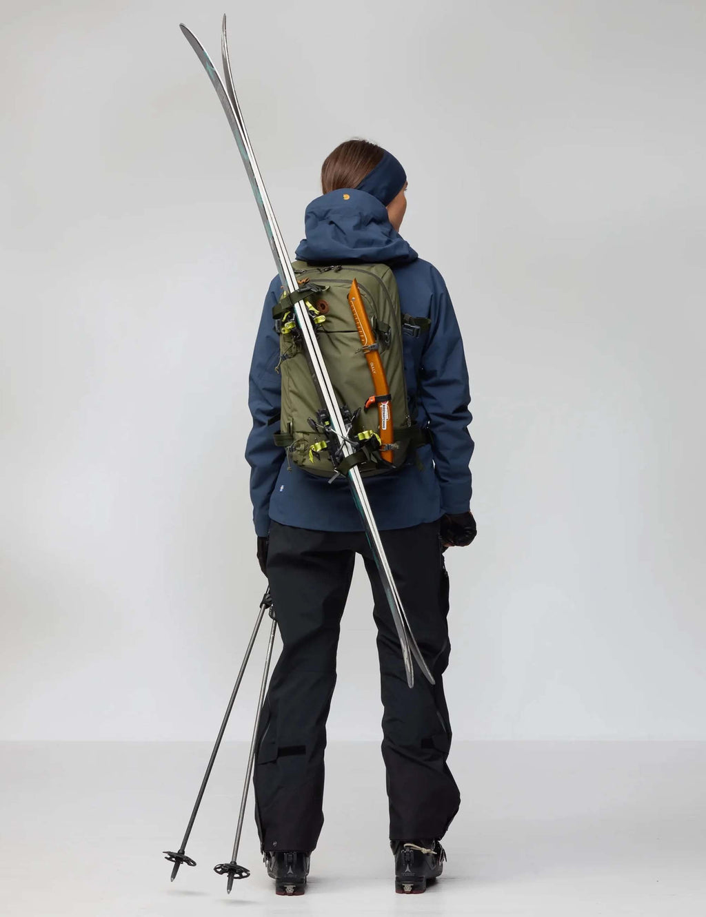 Touring backpack in laurel green on model, with main compartment and front straps