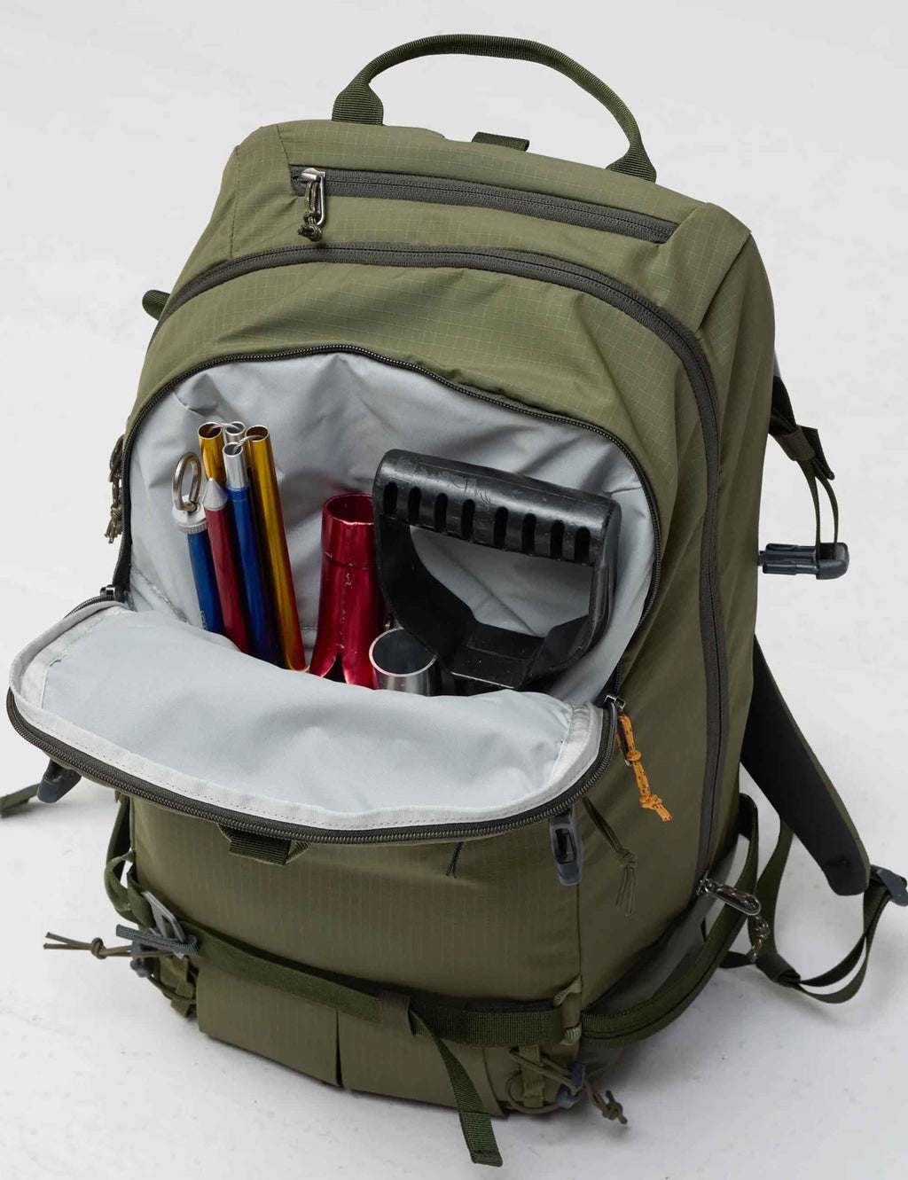 Touring backpack in laurel green, open compartment with internal organizers and bottle sleeve