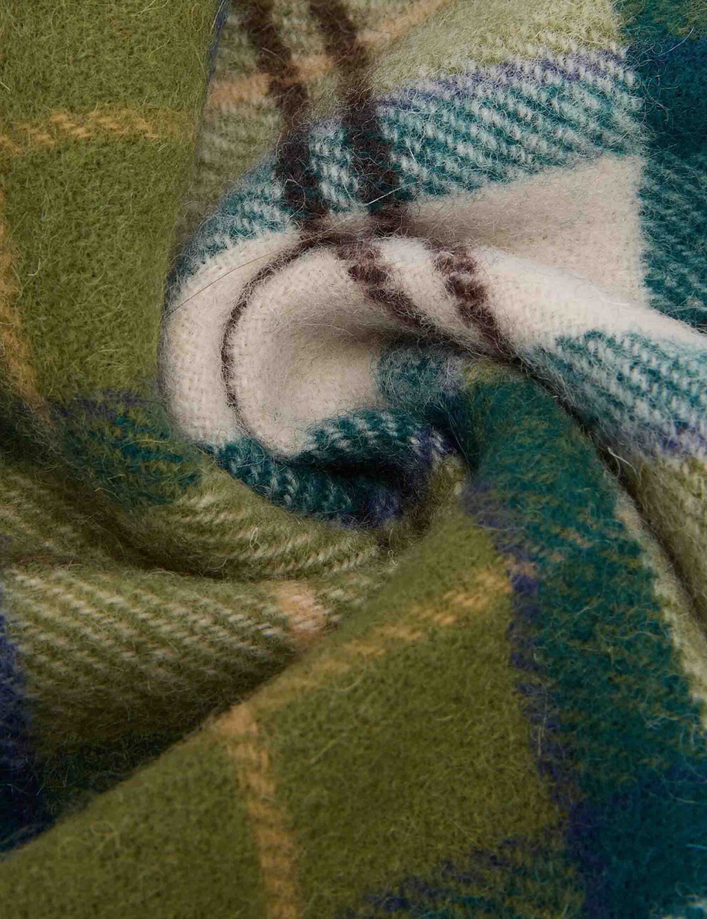 Tartan lambswool scarf close-up with braided plaid weave in green, blue, and cream