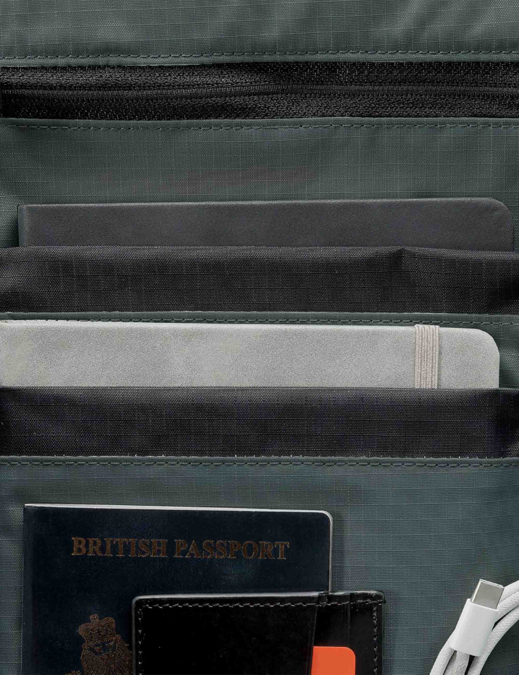 Roll-top backpack interior with lined compartments, card sleeve, and zip pocket