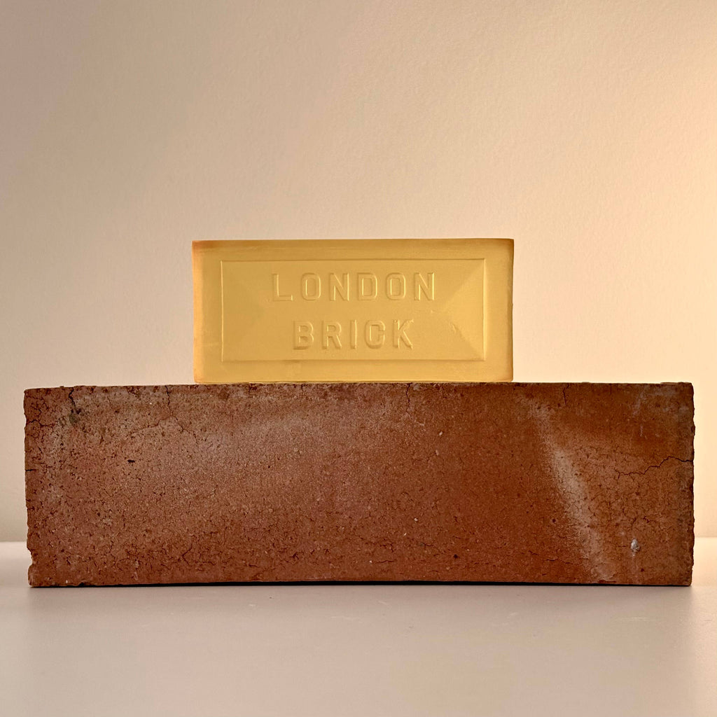 Rectangular brown soap bar with embossed 'LONDON BRICK', with a yellow bar on top.