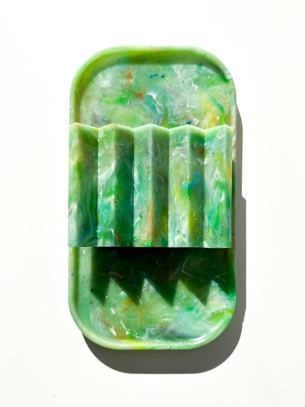 Green marbled recycled plastic tray with ridged top edge detail and rounded shape.