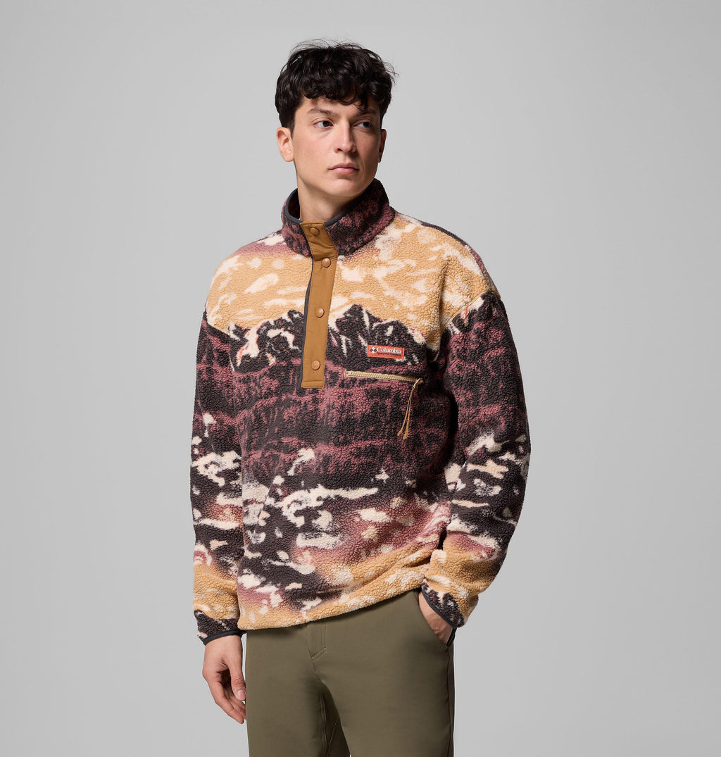 Men's camel landscape-print fleece pullover, angled view, hand in kangaroo pocket, red Columbia chest patch