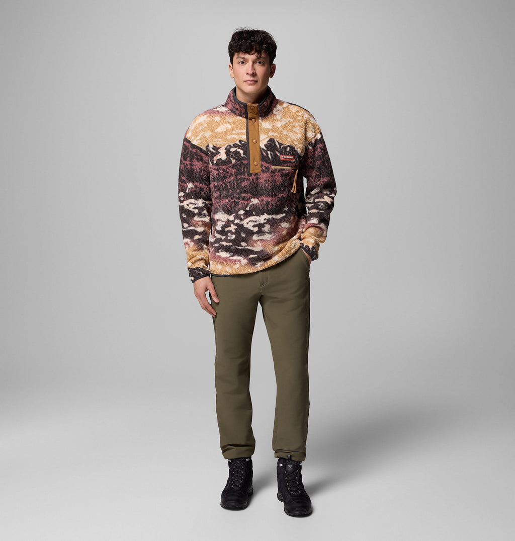Model wearing camel mountain-print fleece pullover with stand collar, worn with olive trousers and boots