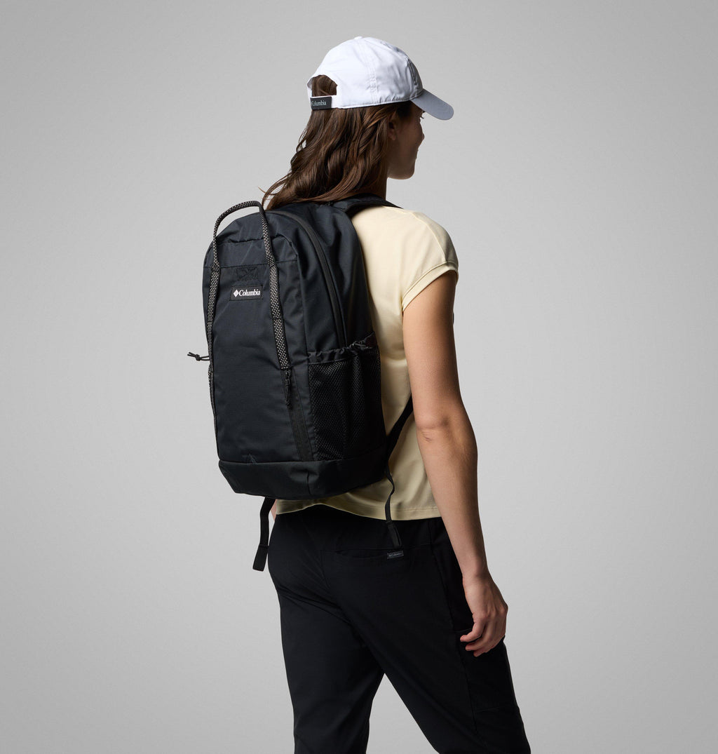 Black 25L backpack worn on the back, with grab handle, front zip pocket and mesh side pocket