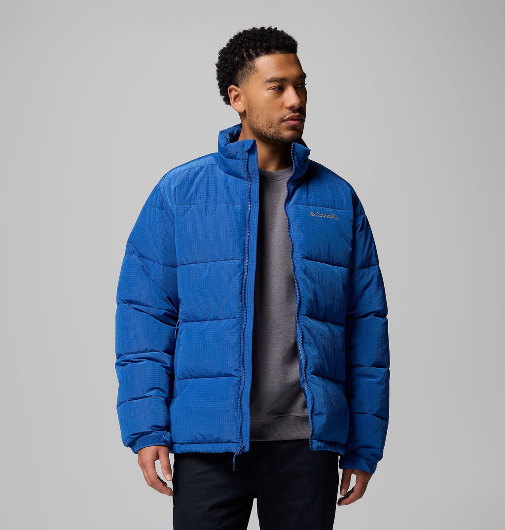 Men's blue puffer jacket worn open, showing stand collar, full zip and chest logo.
