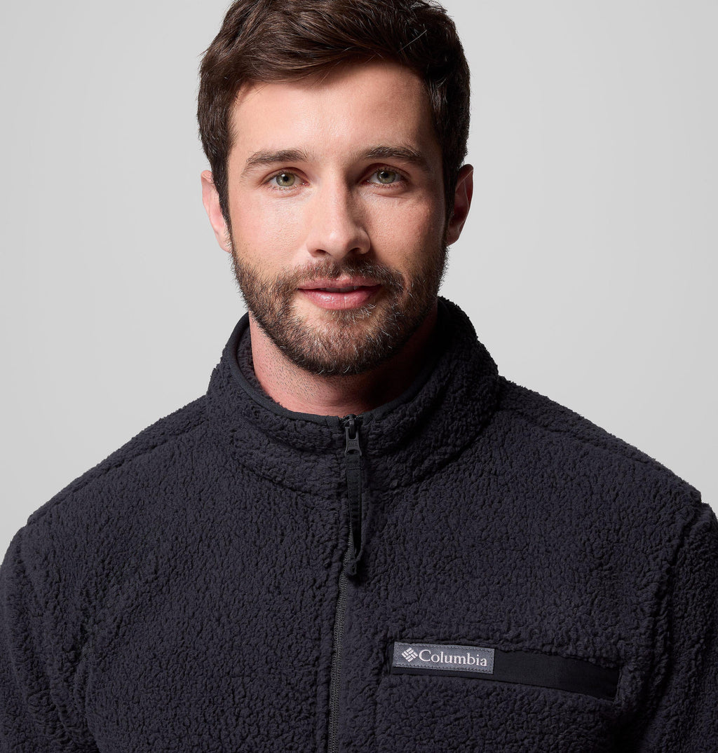 Black high-pile full-zip fleece jacket close-up with Columbia logo chest pocket label.