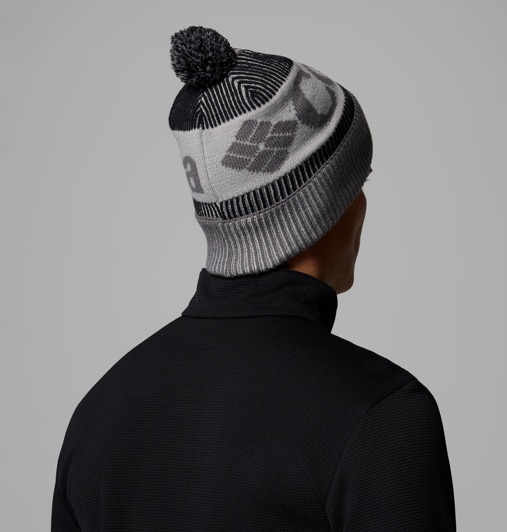 Rib-knit beanie with pom-pom, grey base, and black striped geometric pattern