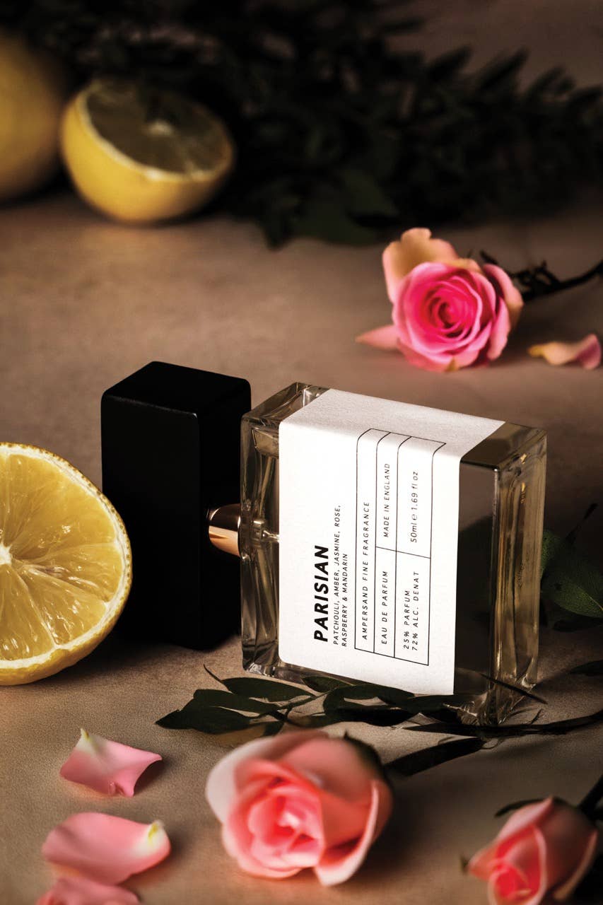 Unisex Eau de Parfum bottle with white label and black cap, with pink rose accents