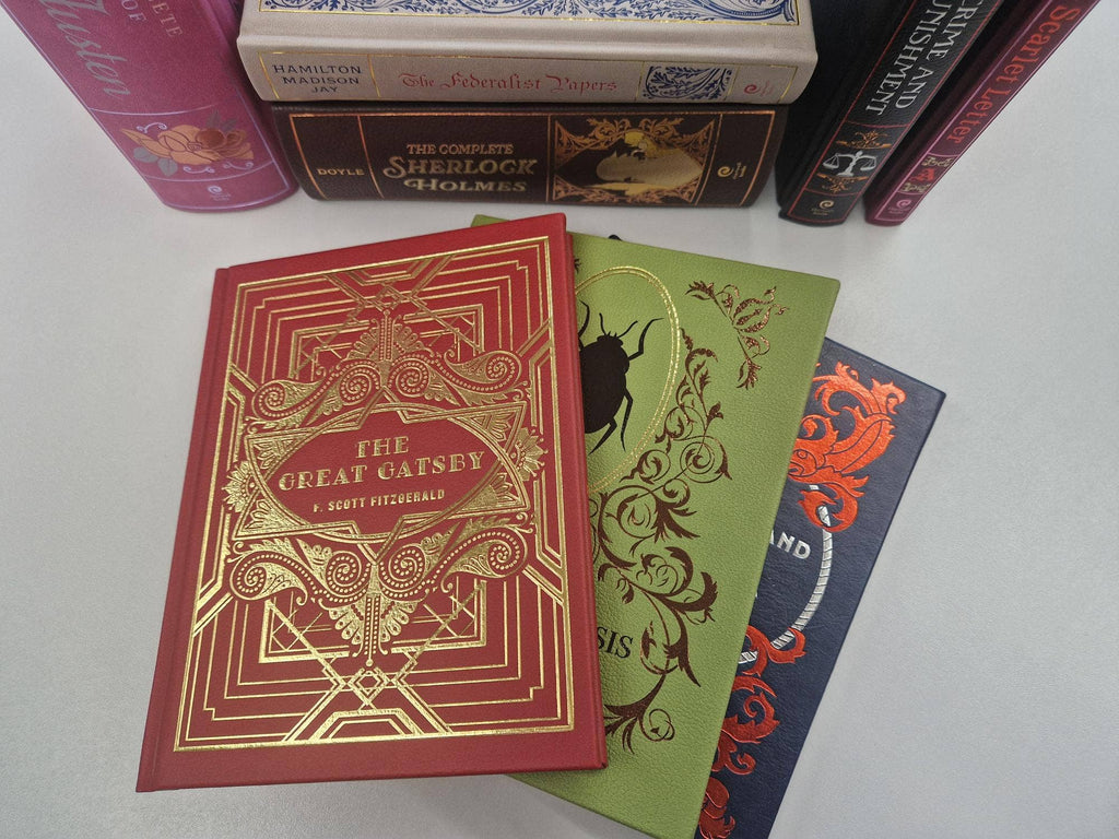 Red hardcover book with gold “THE INFERNO” cover, placed among other books