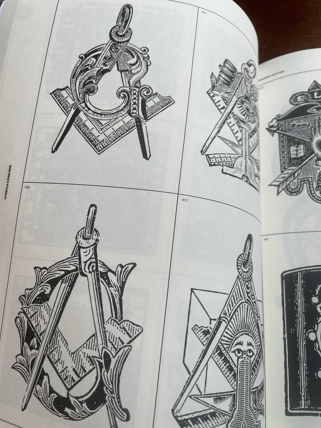 Open symbols and emblems book page with black line-art insignia illustrations
