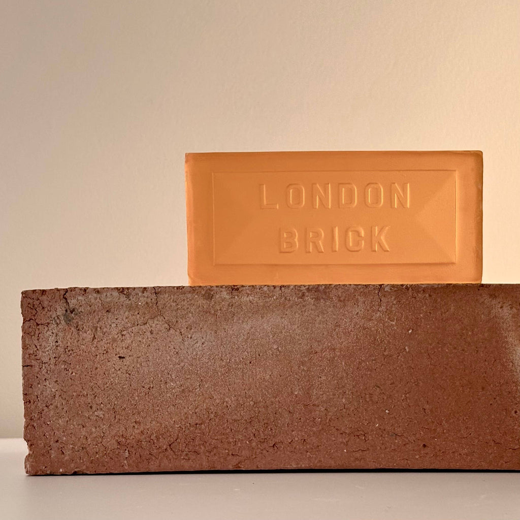 Orange soap bar with embossed "LONDON BRICK" on top of a brown brick block