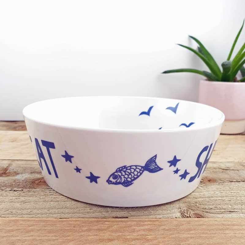 White cat bowl with blue nautical graphics, stars, and fish icons along the side