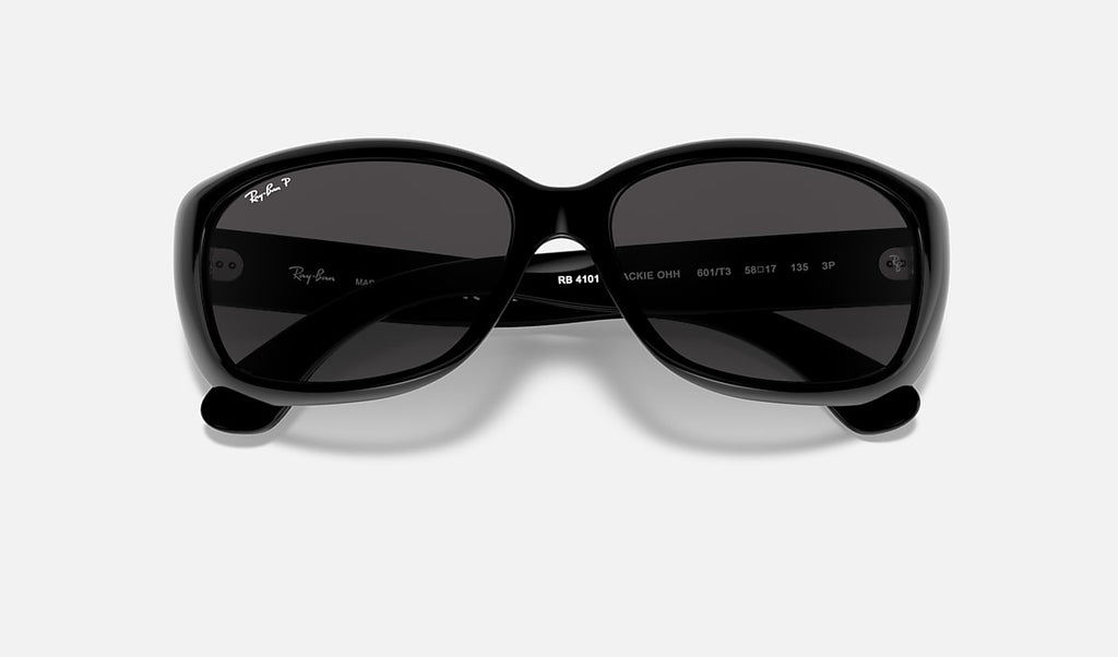 Polished black sunglasses close-up showing lens tint and inner markings