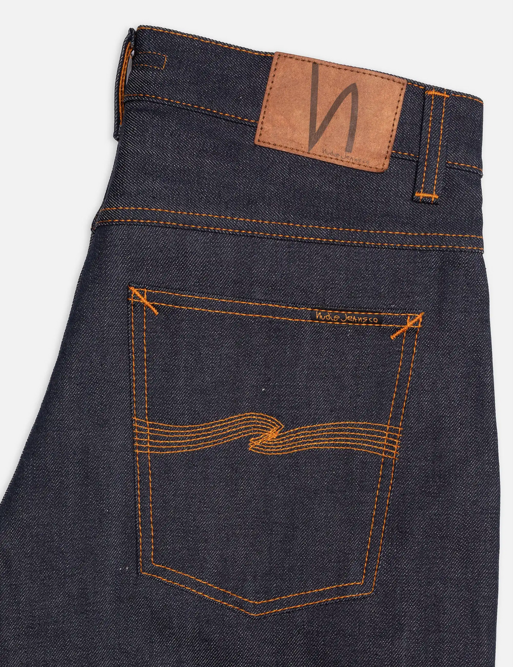 Dark indigo jeans back with leather logo patch, orange stitching, and bartack detail