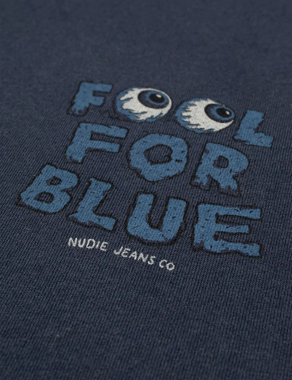 Close-up of dark blue T-shirt chest print with blue "FOOL FOR BLUE" text