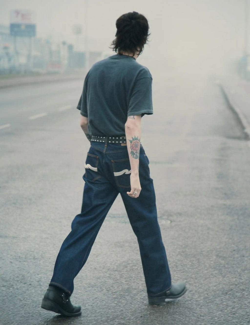 Dark indigo wide-leg jeans with ecru wave graphic on back pockets and orange stitching