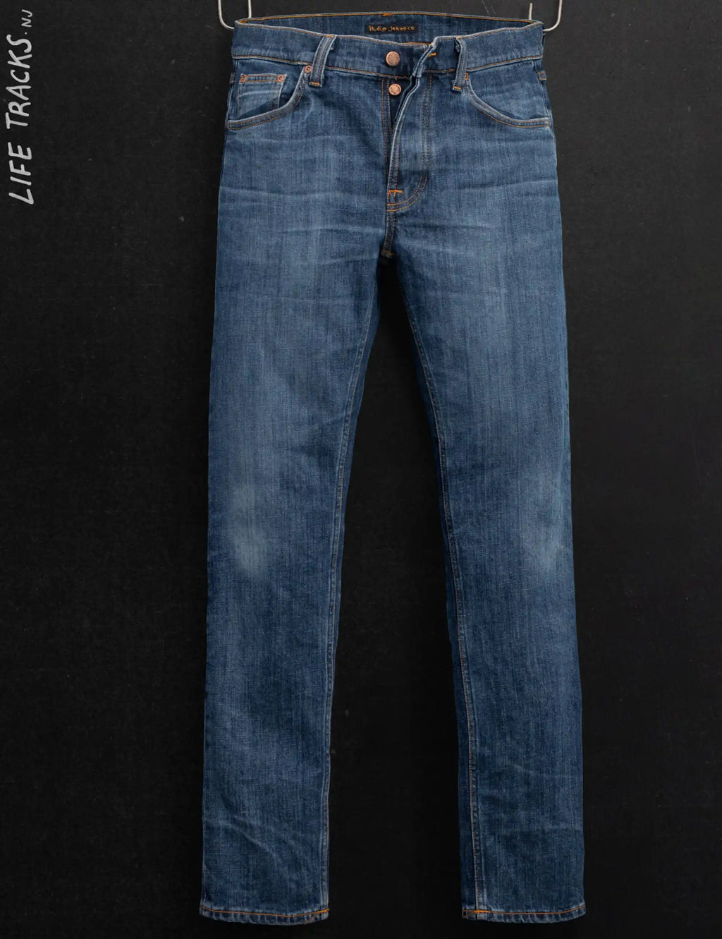 Blue denim jeans with straight legs, orange stitching, and button fly