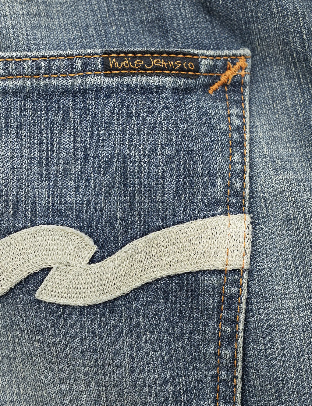 Blue denim back pocket with woven label and embroidered wave detail
