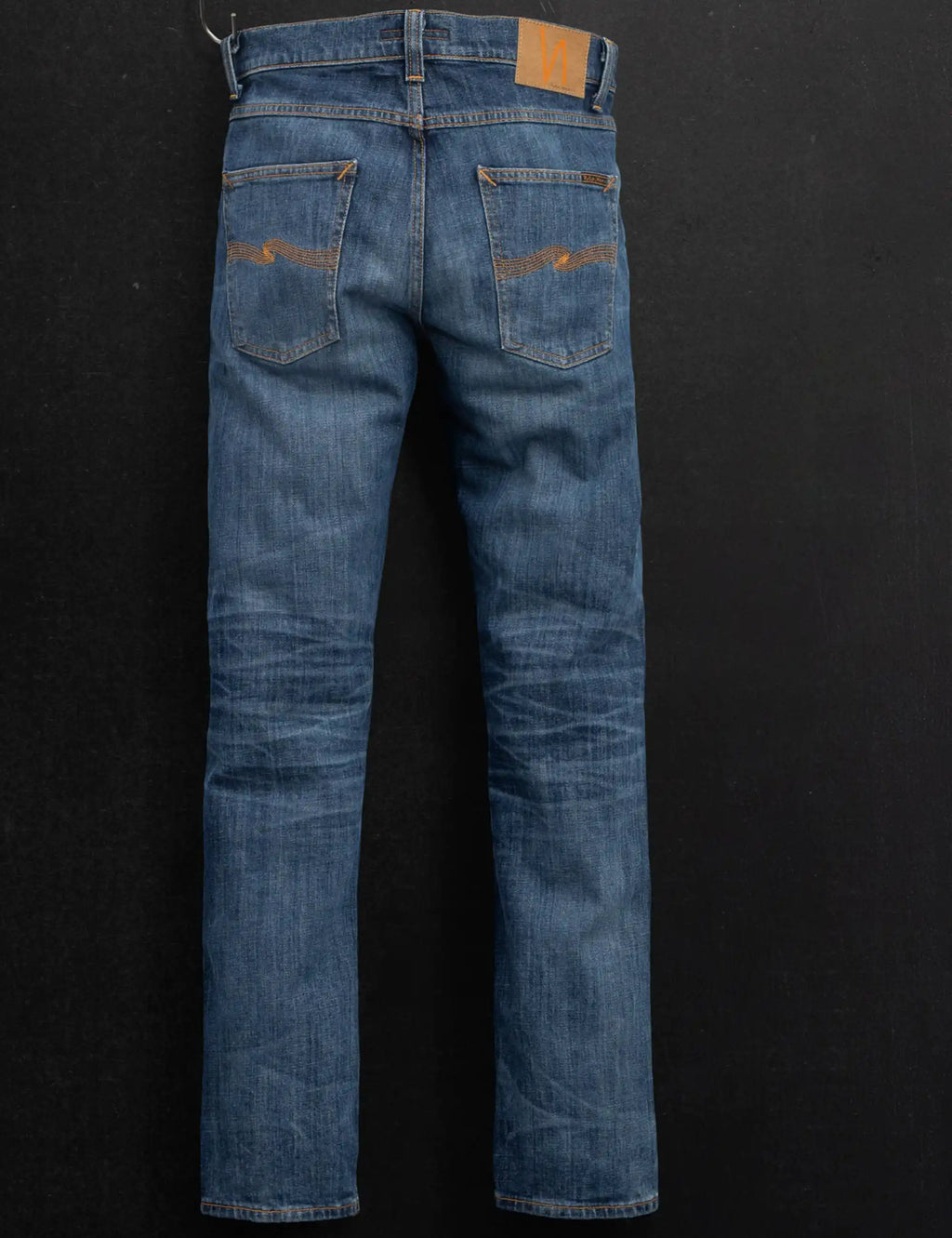 Blue denim jeans back view with rear pockets and orange contrast topstitching