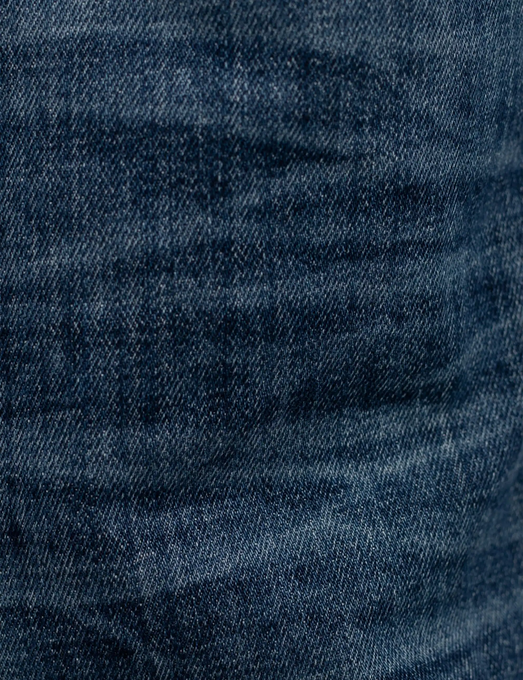 Blue denim jeans fabric texture close-up with subtle wash pattern
