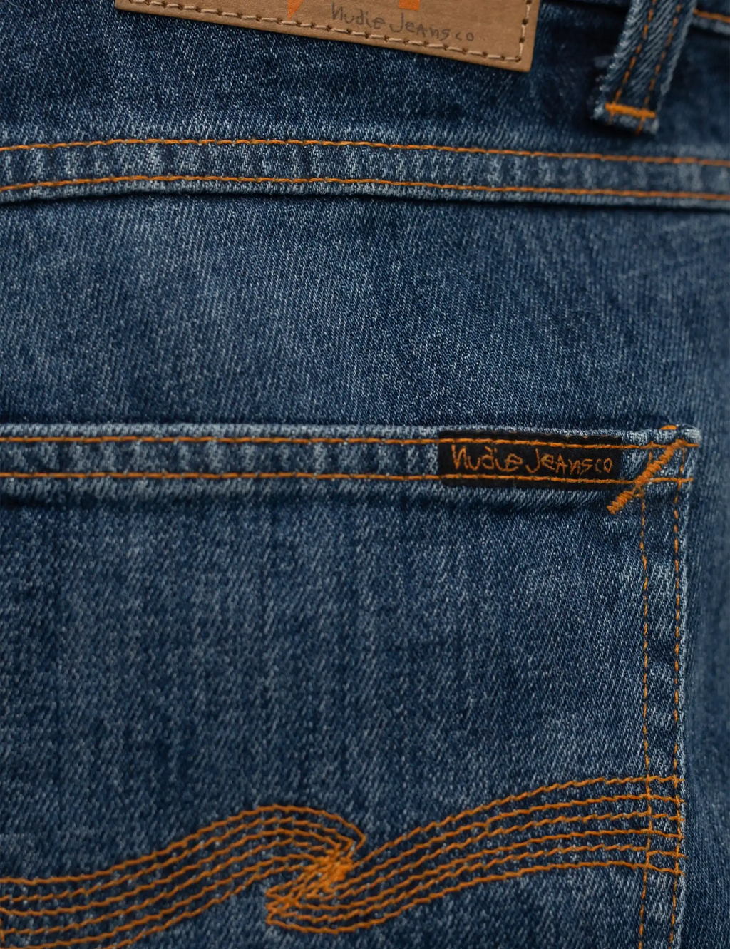 Blue denim jeans back waistband label and orange contrast pocket stitching