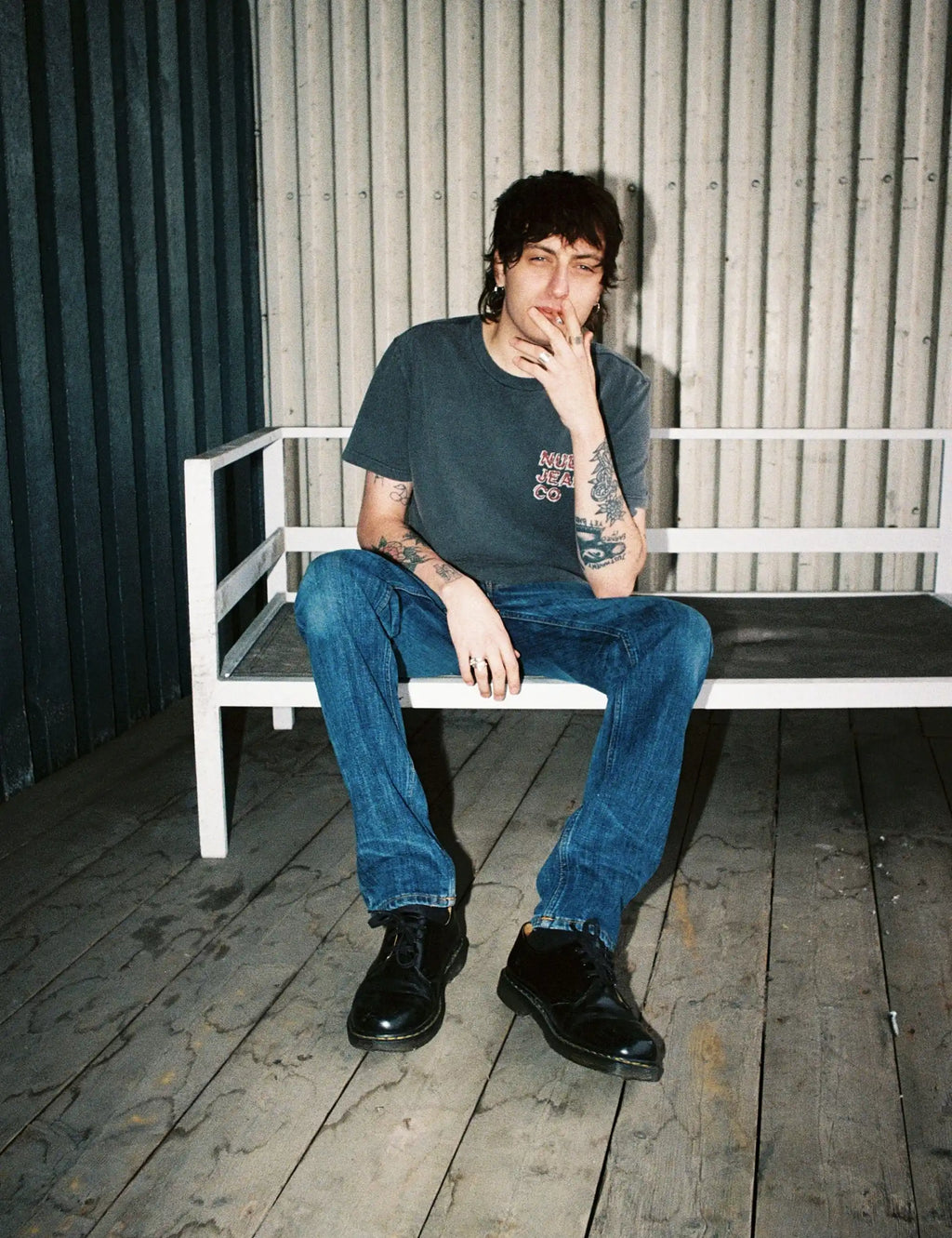 Blue denim jeans worn by a person, full-length view with dark shoes