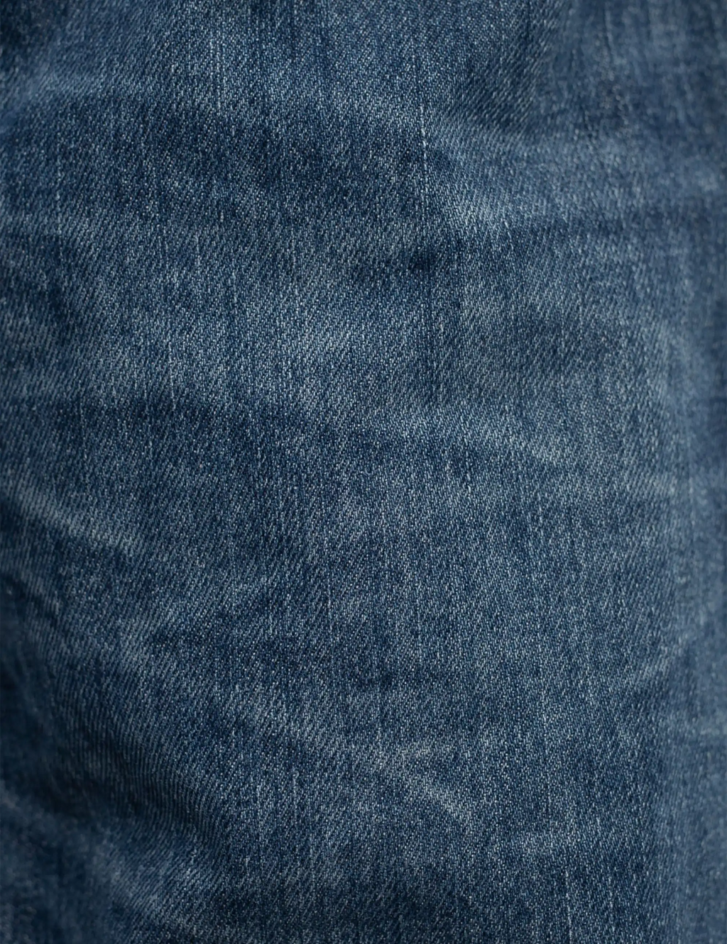 Blue denim jeans fabric close-up with subtle wash texture