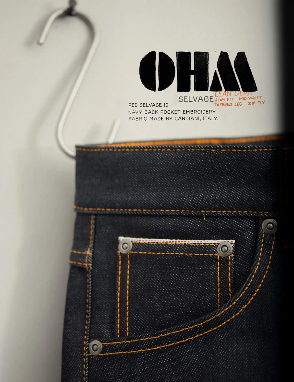 Selvage denim jeans back pocket detail, orange stitching, riveted pocket flaps