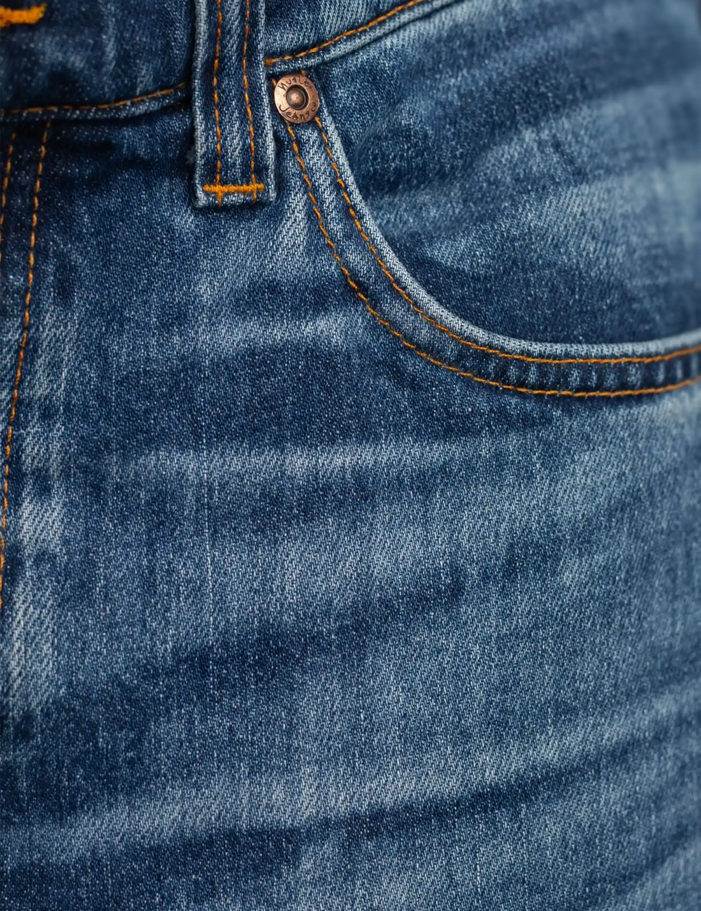 Blue denim jeans with button close, curved pocket opening, and orange topstitching