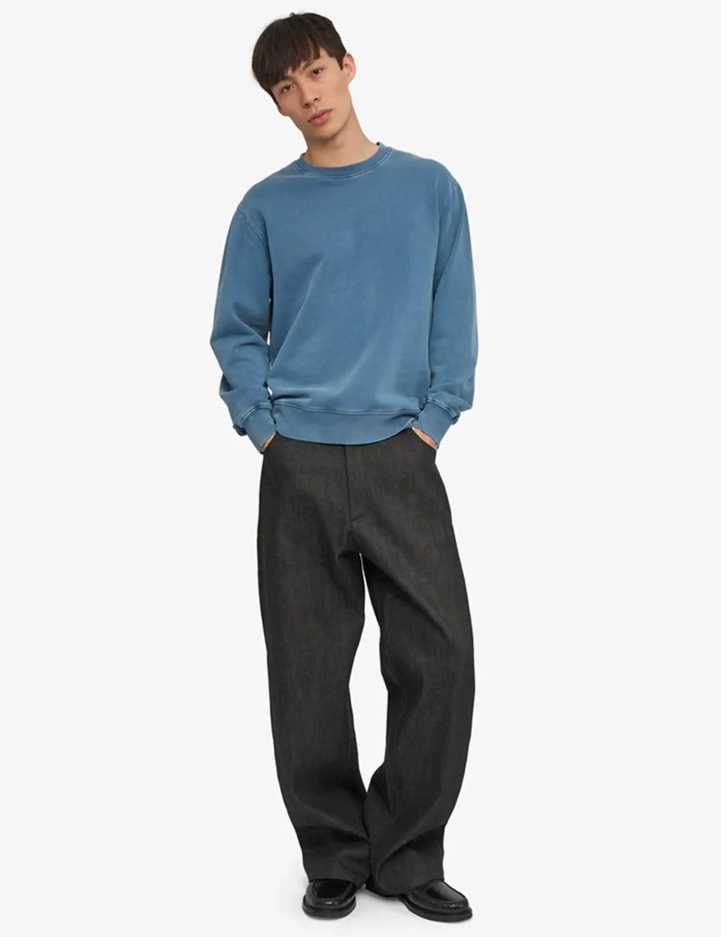 Blue crewneck sweatshirt with long sleeves and ribbed hem on model