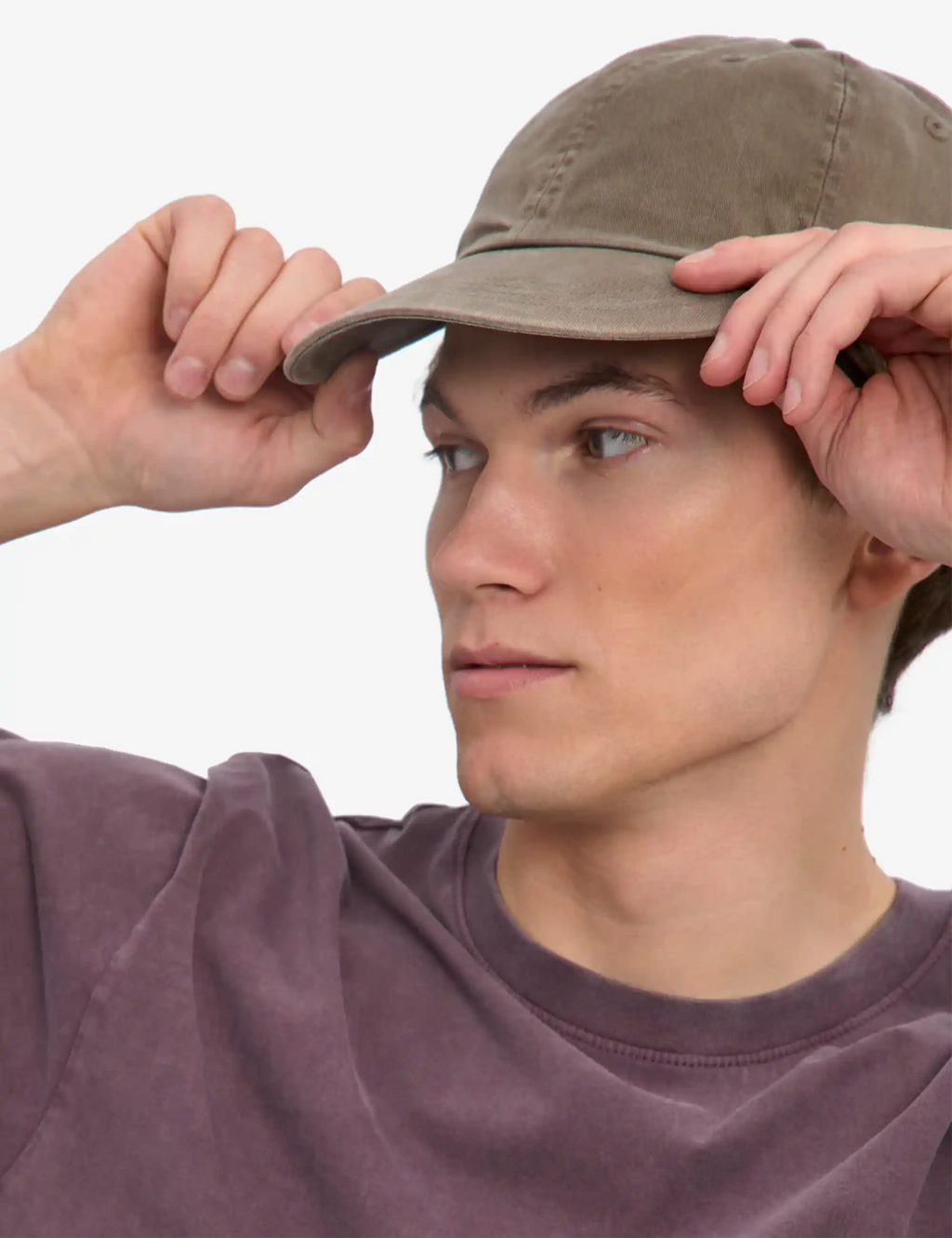 Faded khaki organic 6-panel cap, model adjusting brim with both hands