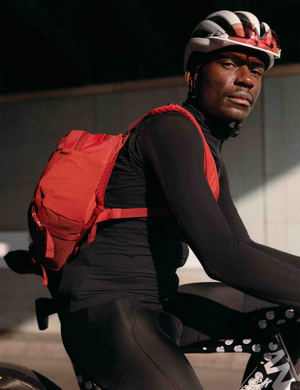 Red 15L sling bag on rider’s back with shoulder strap and front pocket