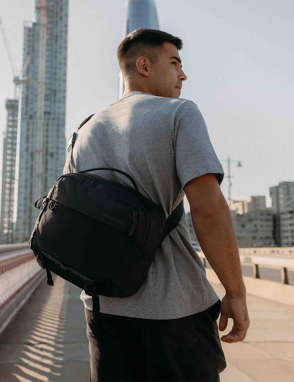 Charcoal 15L sling bag worn on back with mesh-style panel and side pocket
