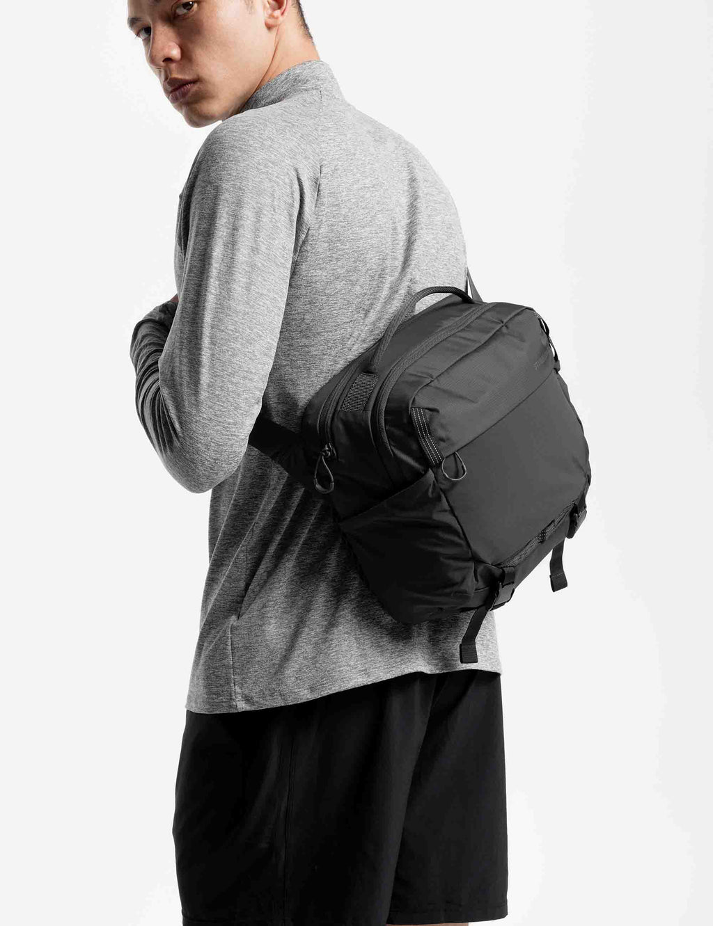 Charcoal 15L sling bag worn across shoulder, zip front and side panels