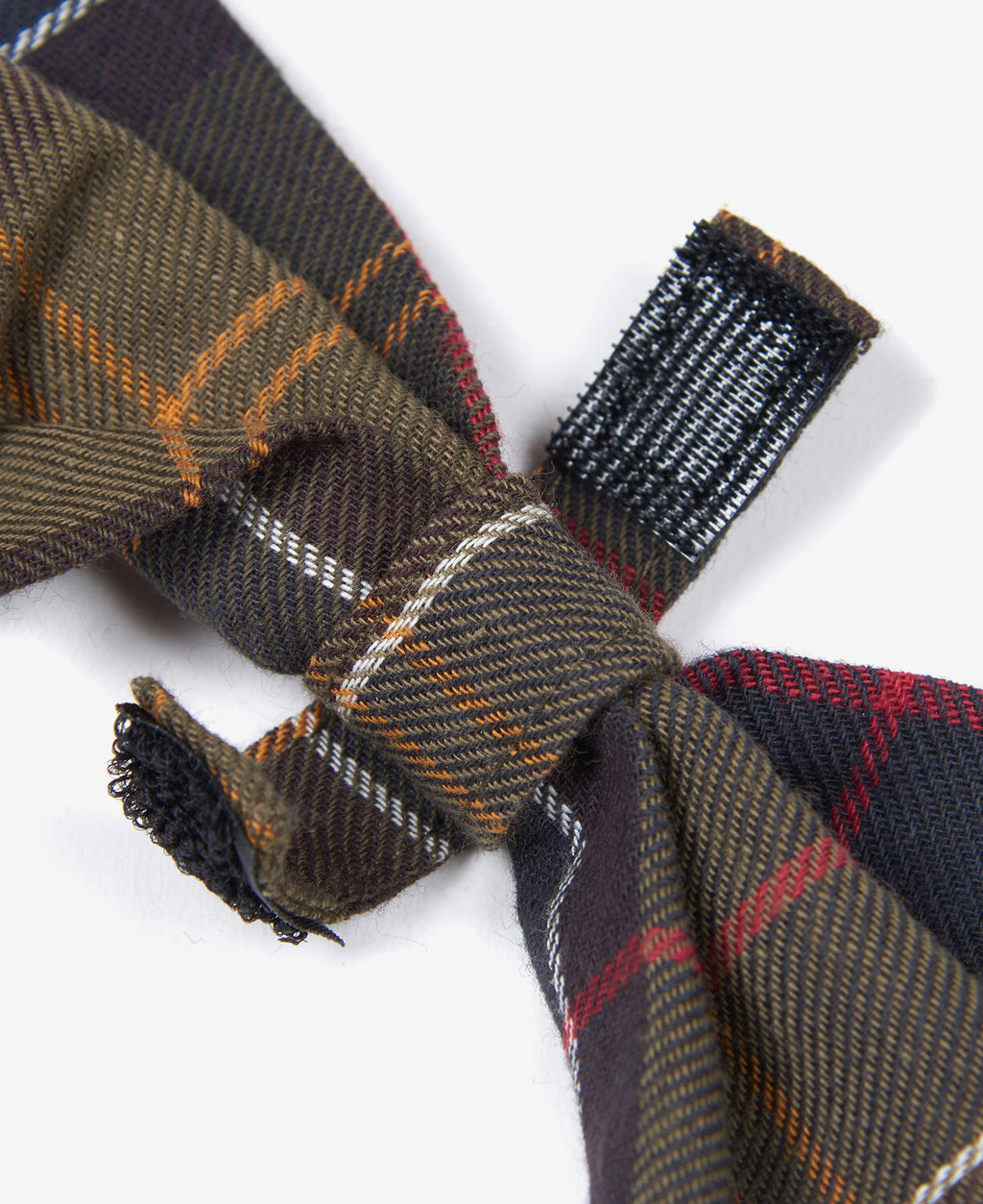 Tartan bow tie detail: plaid fabric knot and fringed ends in navy and red