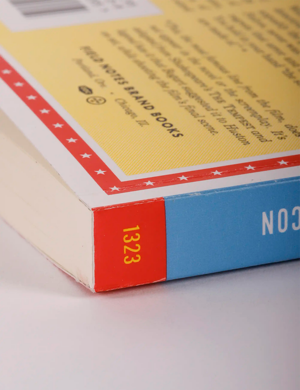 Book corner with red edge and blue cover panel marked “1323”.