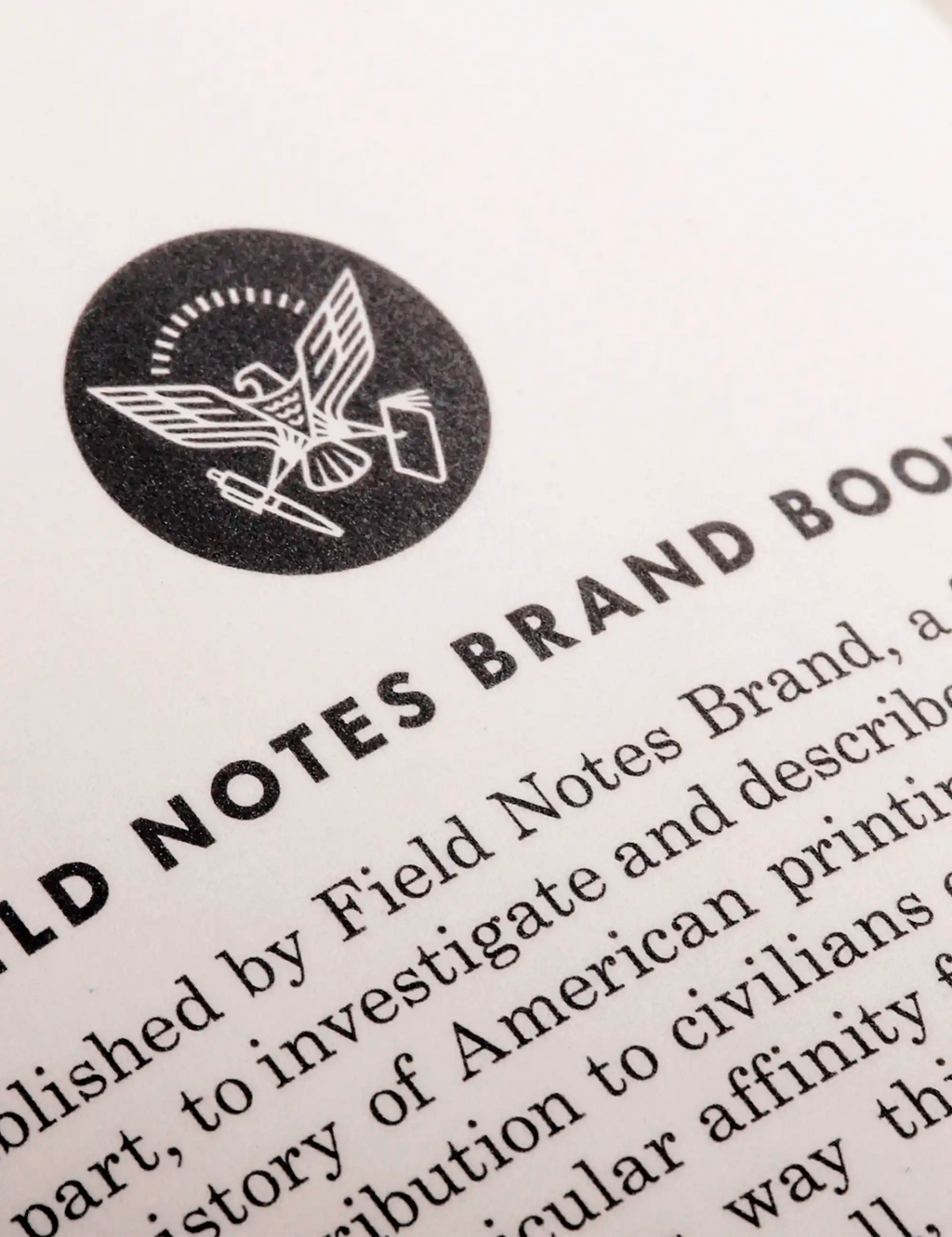 Close-up of the Field Notes seal and surrounding printed text on an off-white page.
