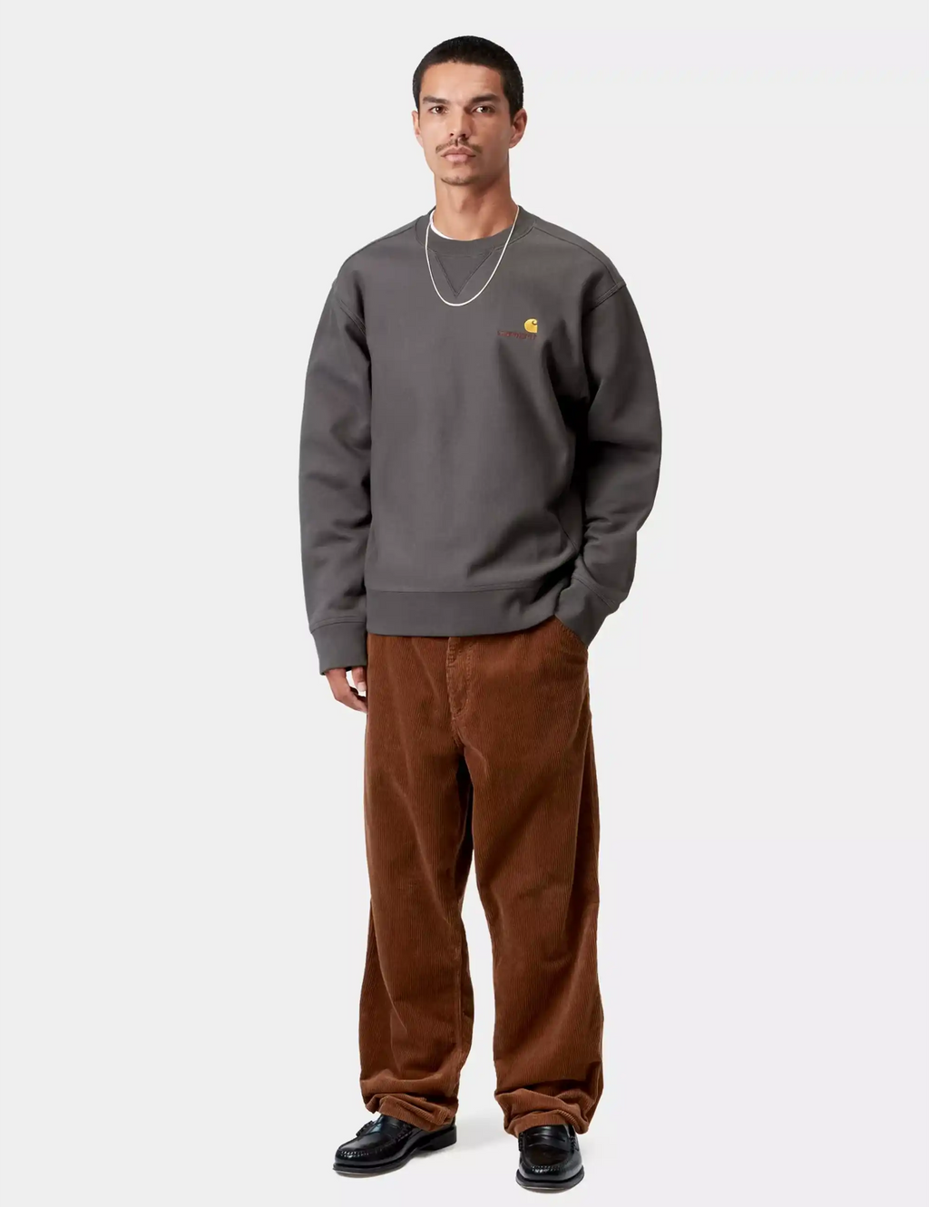 Carhartt WIP graphite crewneck sweatshirt on model, chest logo detail, ribbed cuffs