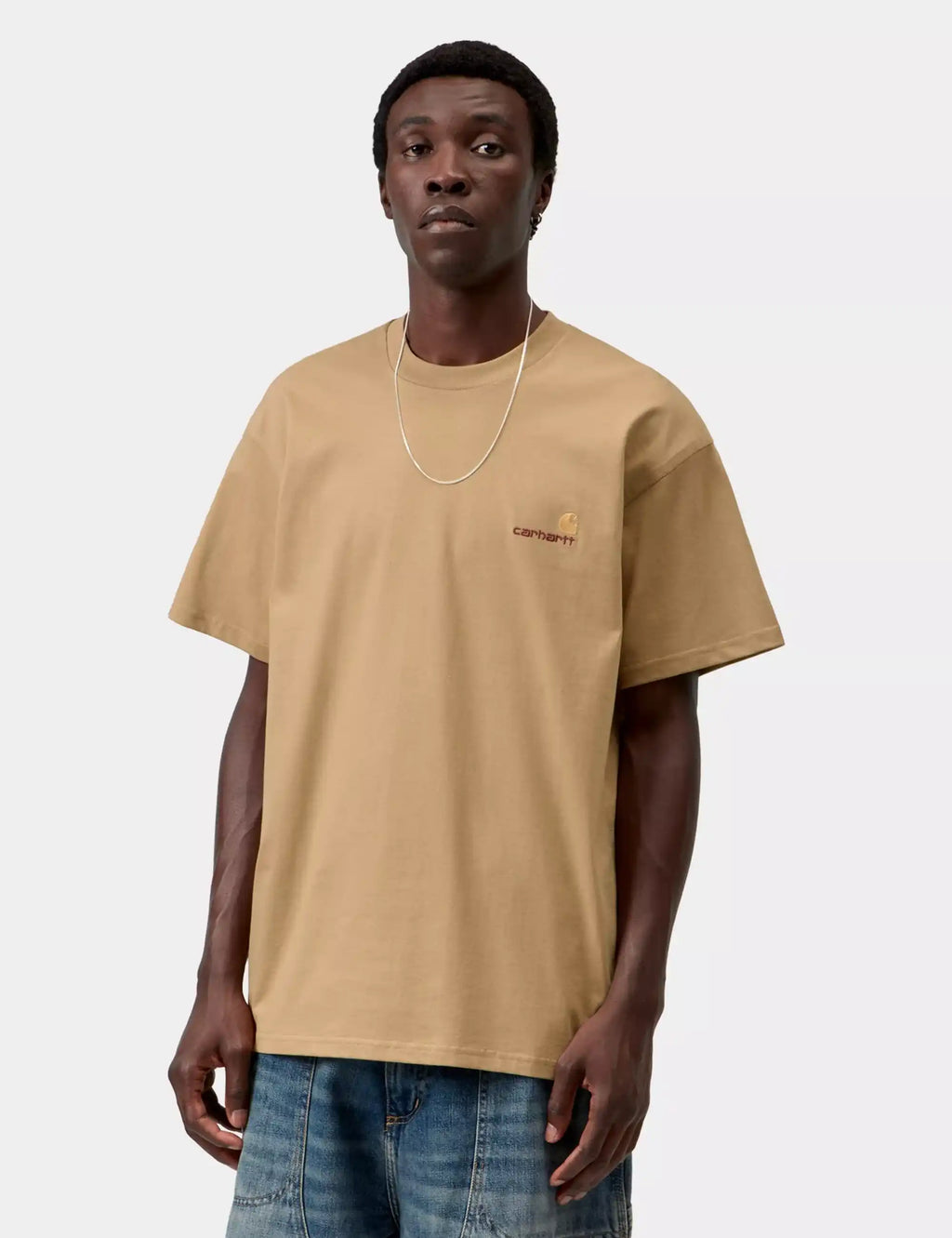 Carhartt WIP dusty tan T-shirt on model with small chest logo, short sleeves