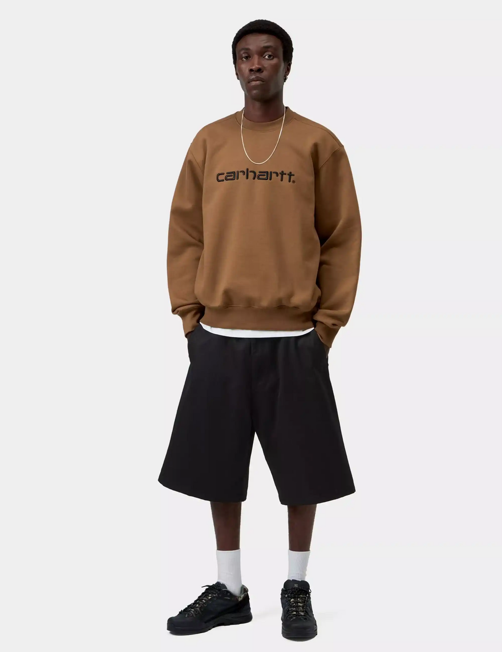 Carhartt crew sweatshirt in brown with Carhartt logo, front view, ribbed hem