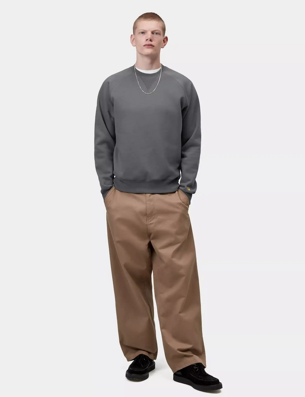 Dark gray crewneck sweatshirt worn with tan pants; ribbed cuffs and hem