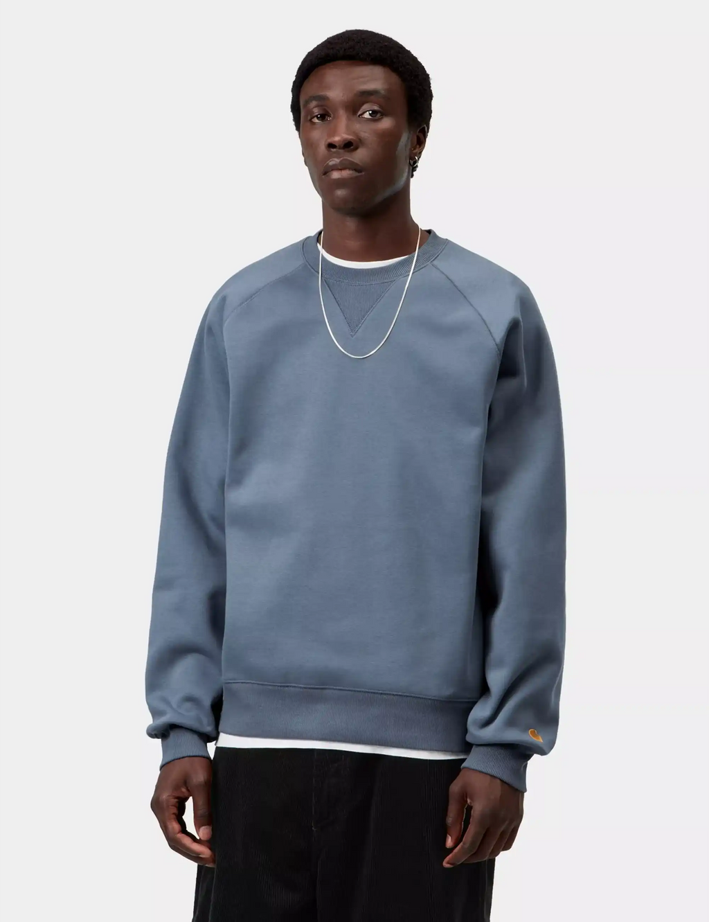 Blue crewneck sweatshirt worn by model, ribbed neckline, cuffs, and hem
