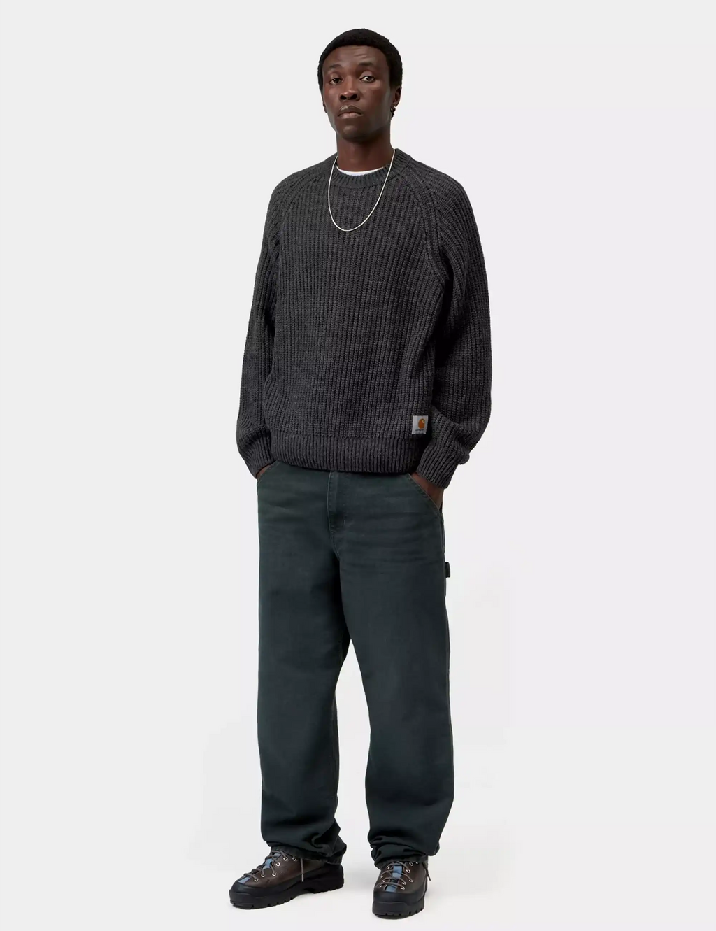 Soot gray knit crew sweater worn with jeans; ribbed cuffs and hem, logo patch