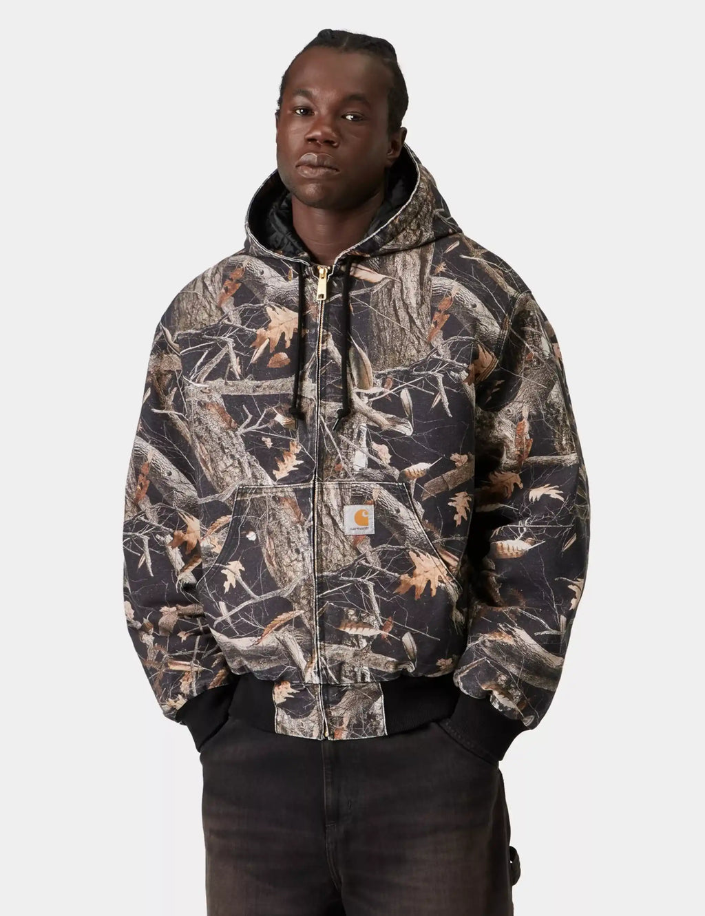 Carhartt WIP OG Active jacket in black feather-tree camouflage, zip front, ribbed cuffs.